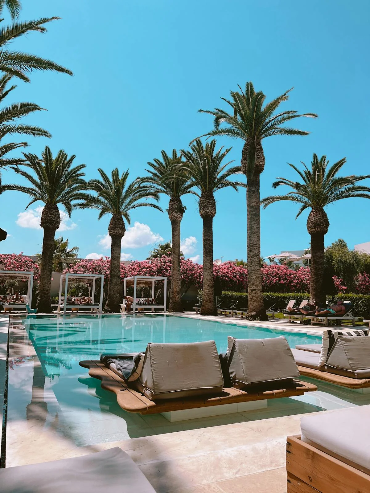 Poolbereich mit Palmen in einer Hotelanlage